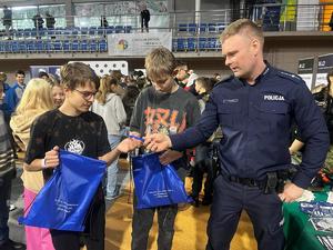 Umundurowani policjanci w trakcie pogadanek i pokazu sprzętu policyjnego na Targach Edukacji i Festiwalu Zawodów w Hali Widowiskowo-Sportowej.
